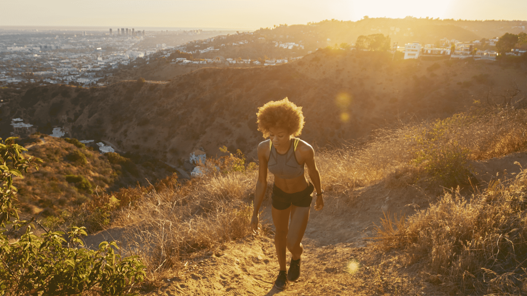 woman walking uphill at sunset